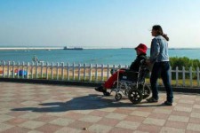 来宾八旬老人推轮椅带老伴游中国(为了方便推轮椅带老伴出门)